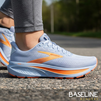 Blue and orange running shoes with 'Brooks' logo on a road, 'Baseline Runners' branding visible.