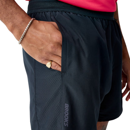 Man wearing black Brooks running shorts on a white background