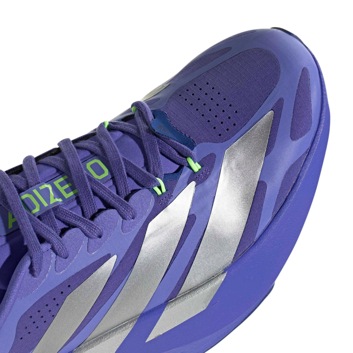 Close-up of a Adidas running shoe with metallic silver side stripes and bright green laces on a white background.