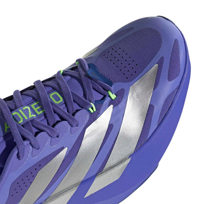 Close-up of a Adidas running shoe with metallic silver side stripes and bright green laces on a white background.