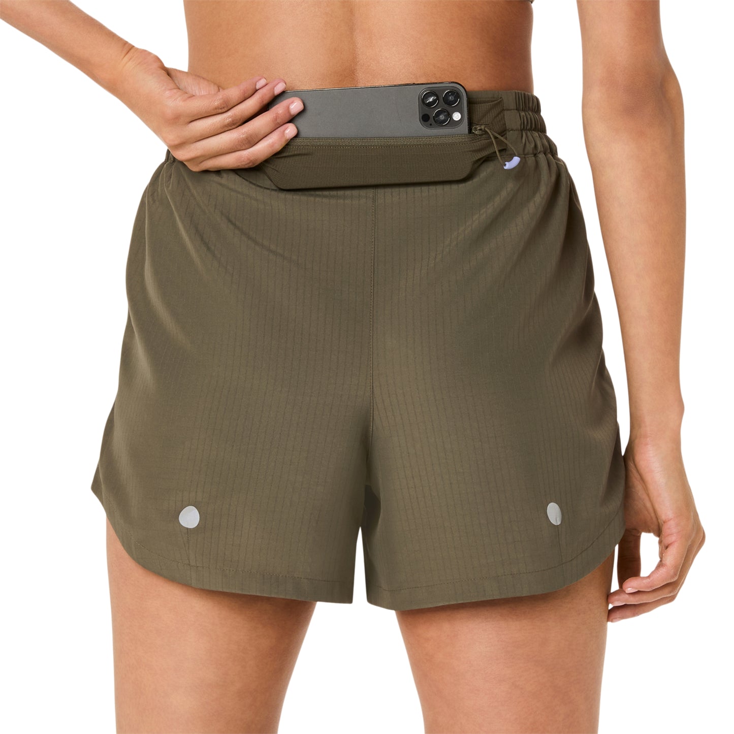 Person wearing olive green Asics shorts on a white background