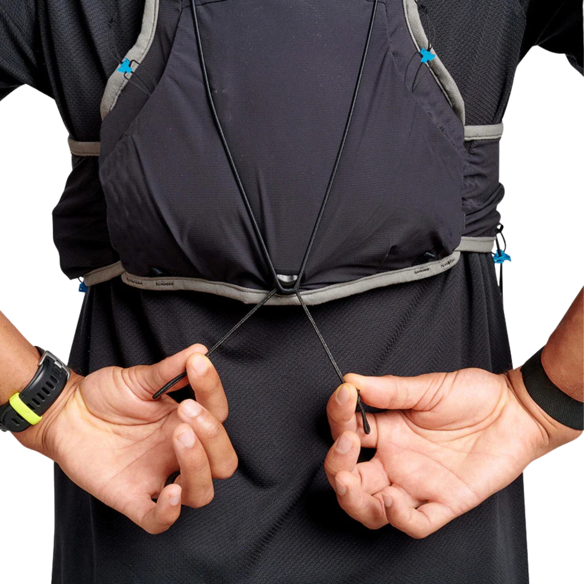 Person adjusting a black hydration vest with visible straps on a white background