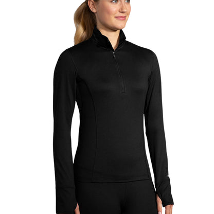 Woman wearing a black long sleeve Brooks shirt on a white background