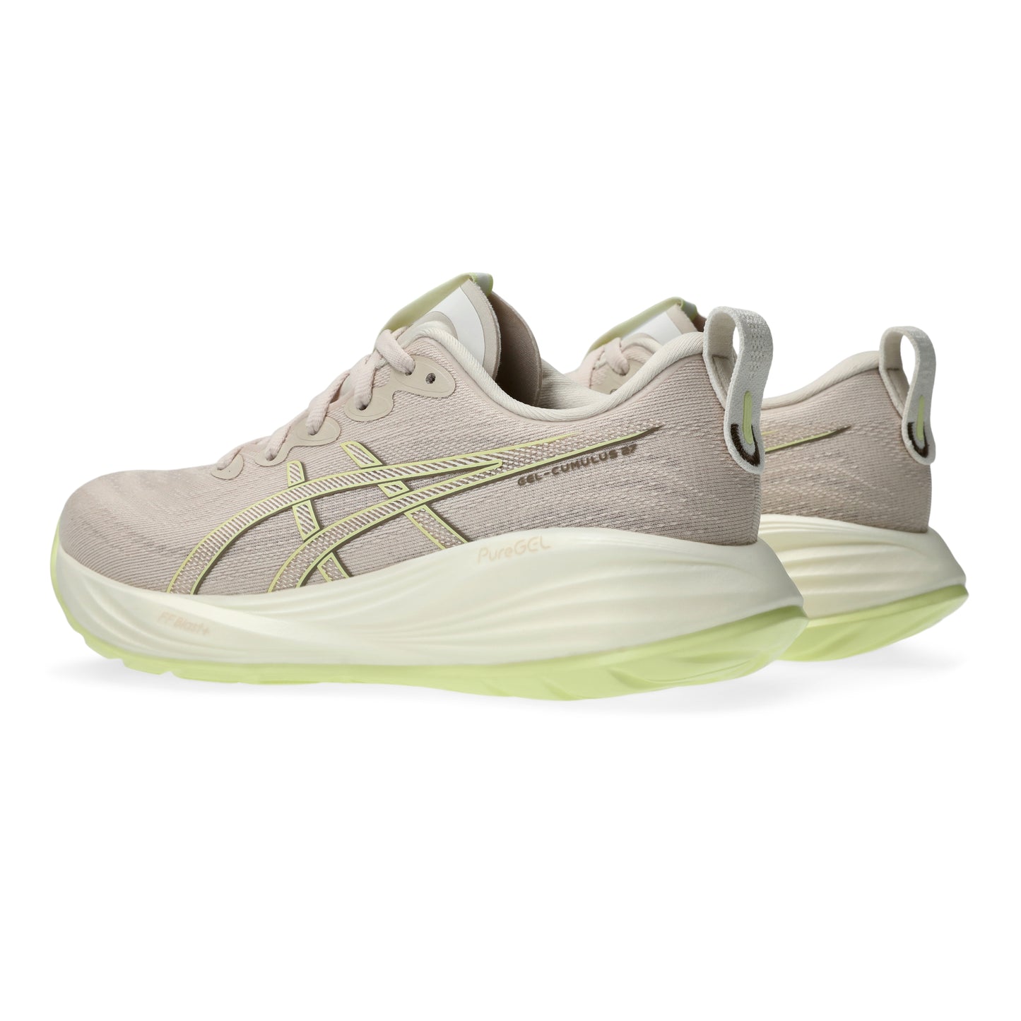 Pair of beige running shoes with green sole on a white background