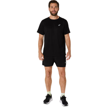 Man wearing a black t-shirt and shorts with a visible brand logo on a white background