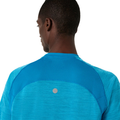 Person wearing a blue Asics shirt on a white background