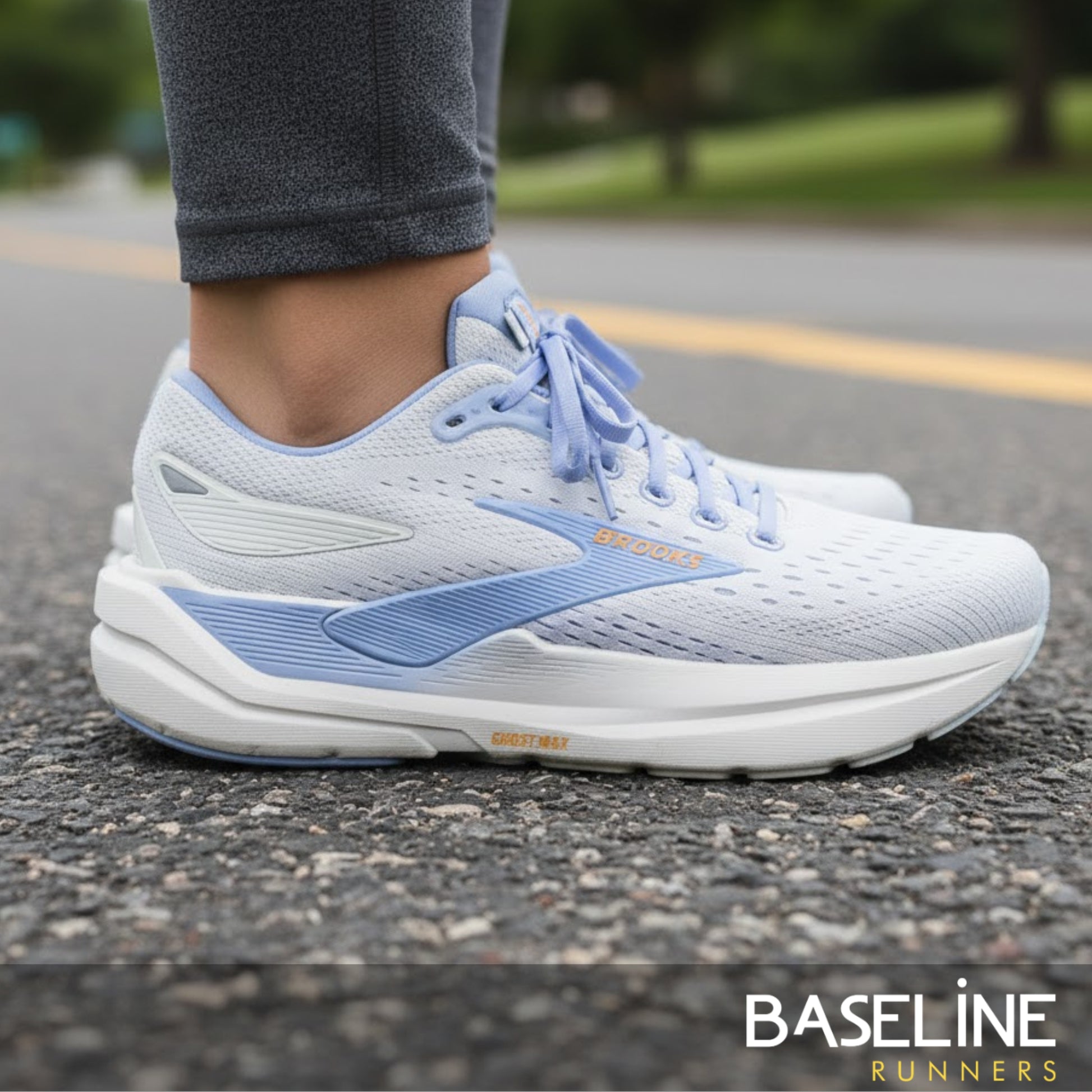 White and blue running shoes on a road with 'Baseline Runners' branding.