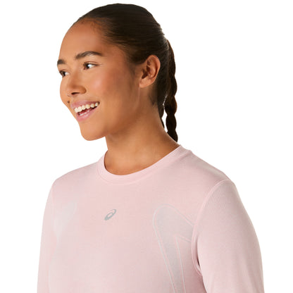 Woman wearing a light pink long-sleeve athletic shirt with a brand logo on a white background