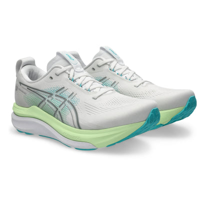 White Asics running shoe with green sole on a white background