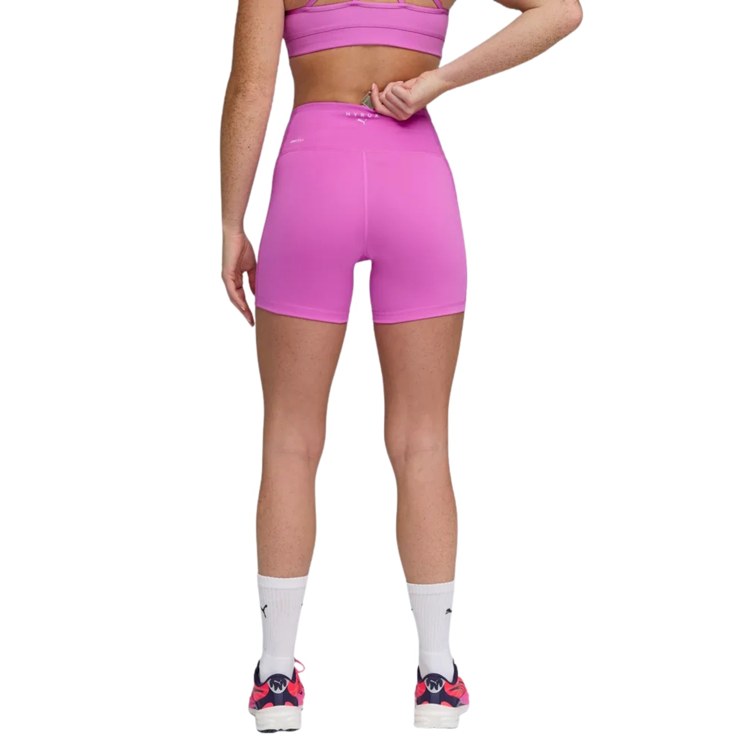 Person wearing pink Puma tights on a white background