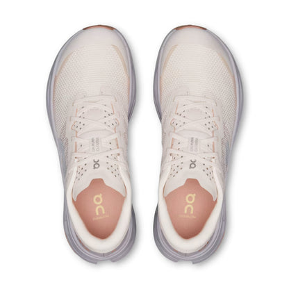 A pair of On running shoes shown from a top-down view, featuring a light beige mesh upper, white laces, and a peach-colored insole with the gold On logo.