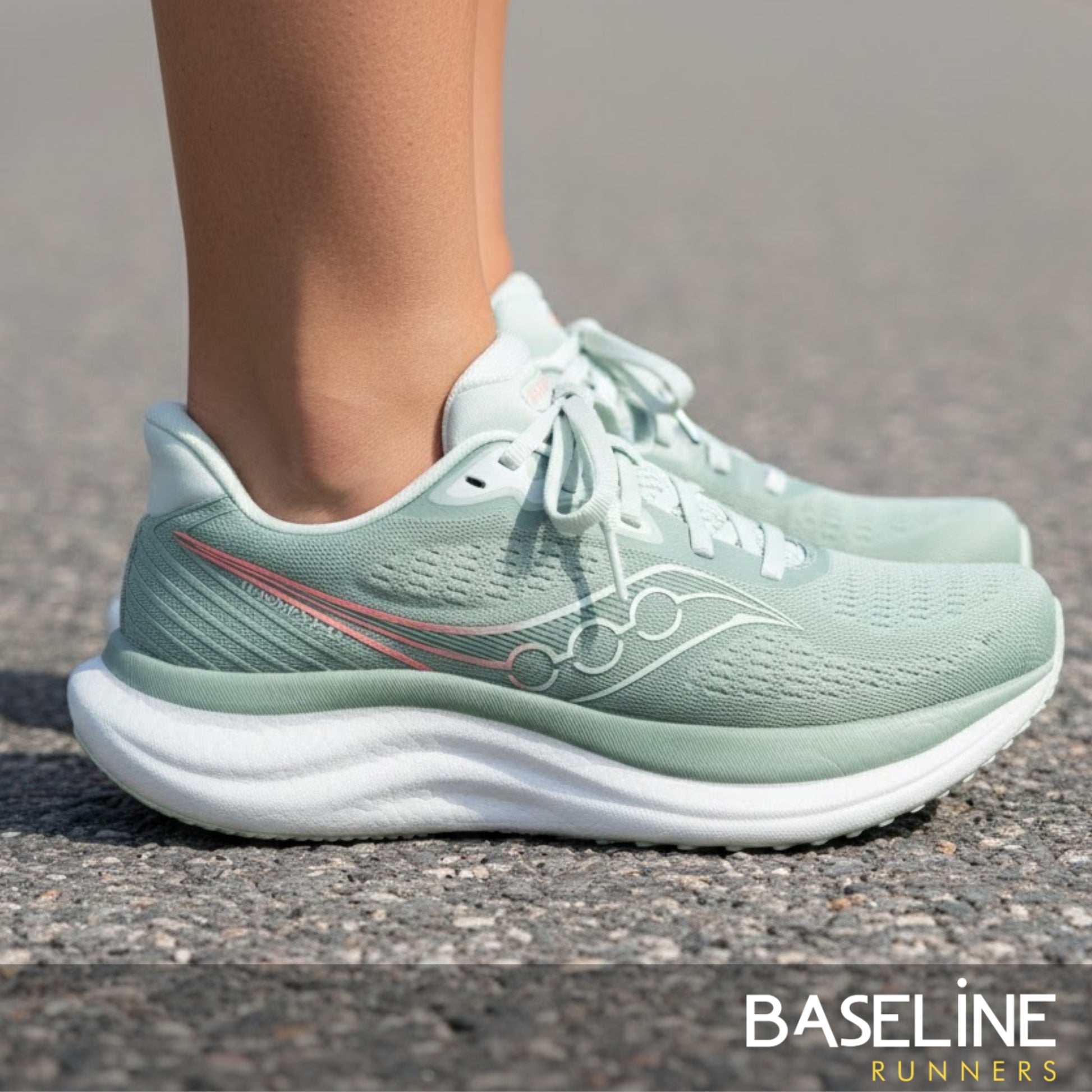 Olive green Saucony running shoe with wording Triumph 23 on the side of the shoe 