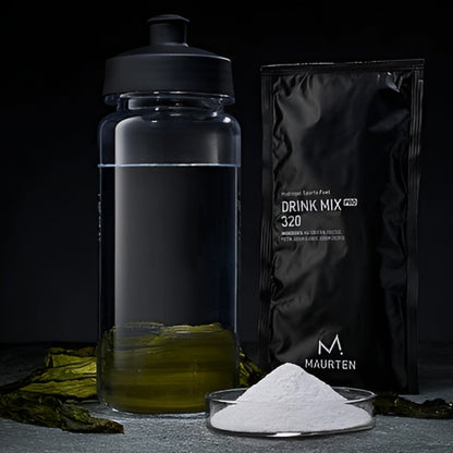 Maurten drink mix with a water bottle and powder on a dark background