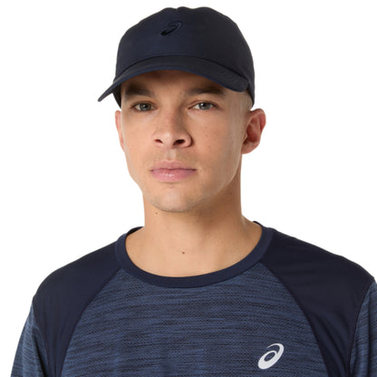Man wearing a navy cap and matching athletic shirt with a logo on a white background