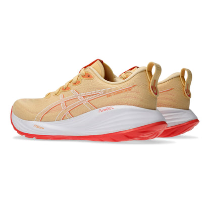 Light orange running shoes with red soles on a white background
