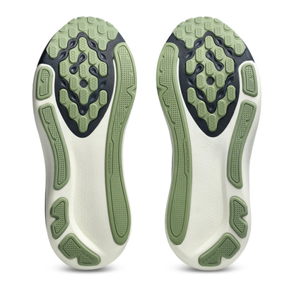 Close-up of a pair of white athletic shoes with green sole pattern on a white background