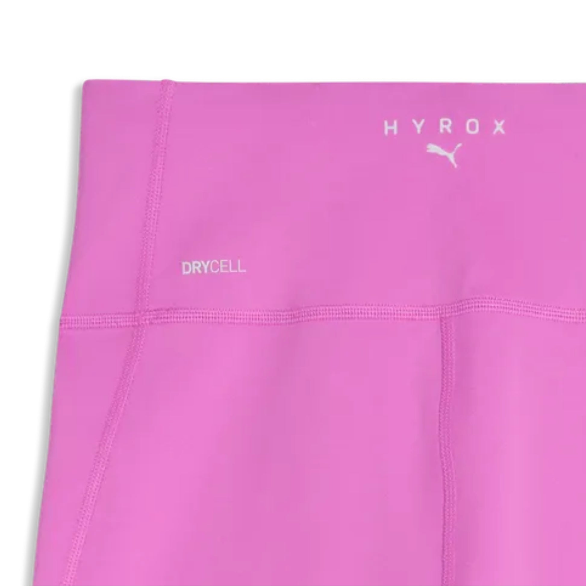 Close-up of a pink Puma tight with 'HYROX' and 'DRYCELL' text on a white background