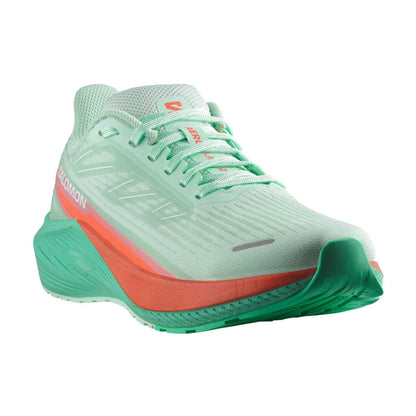 Light green running shoe with a red sole on a white background