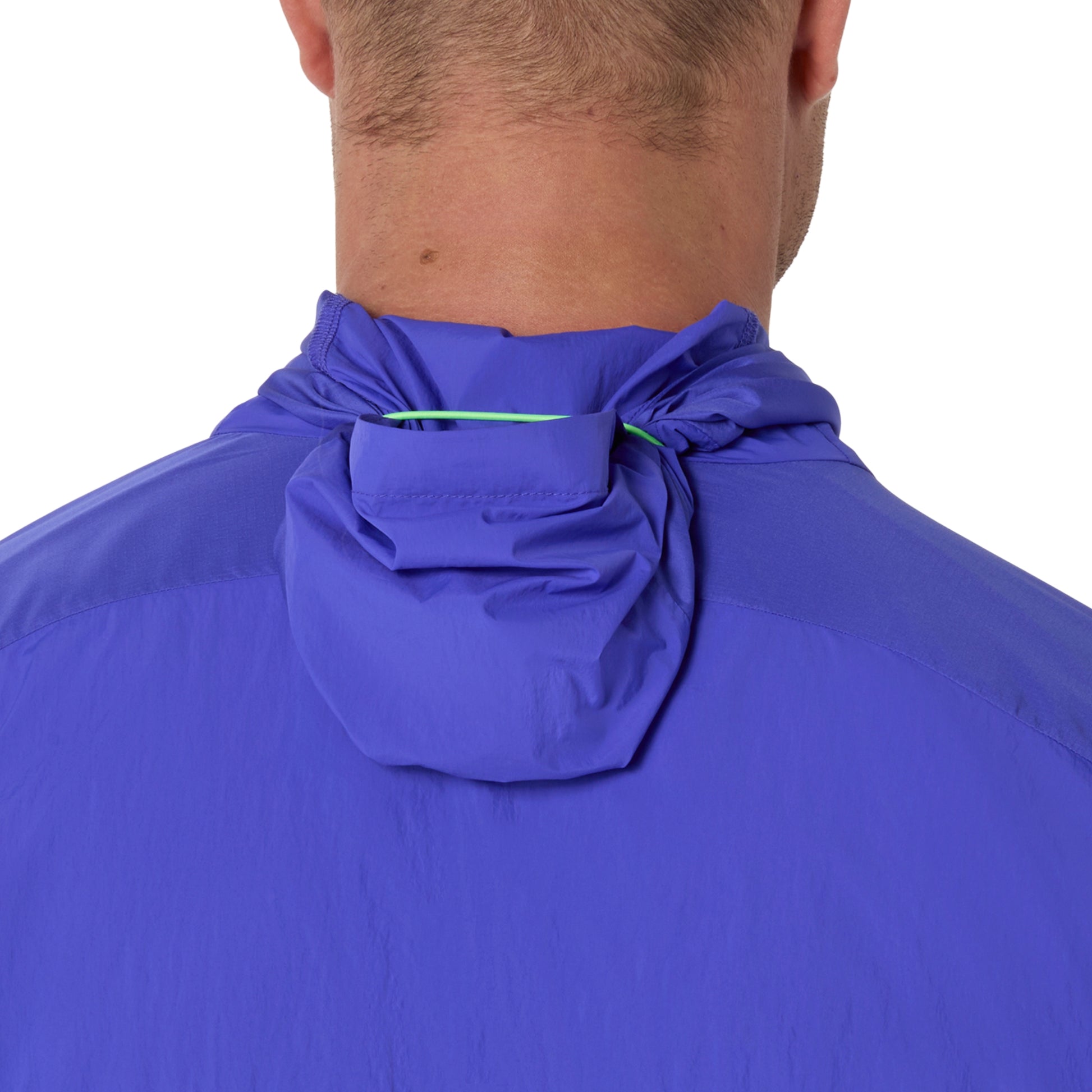 Close-up of a person wearing a hooded Asics jacket on a white background 