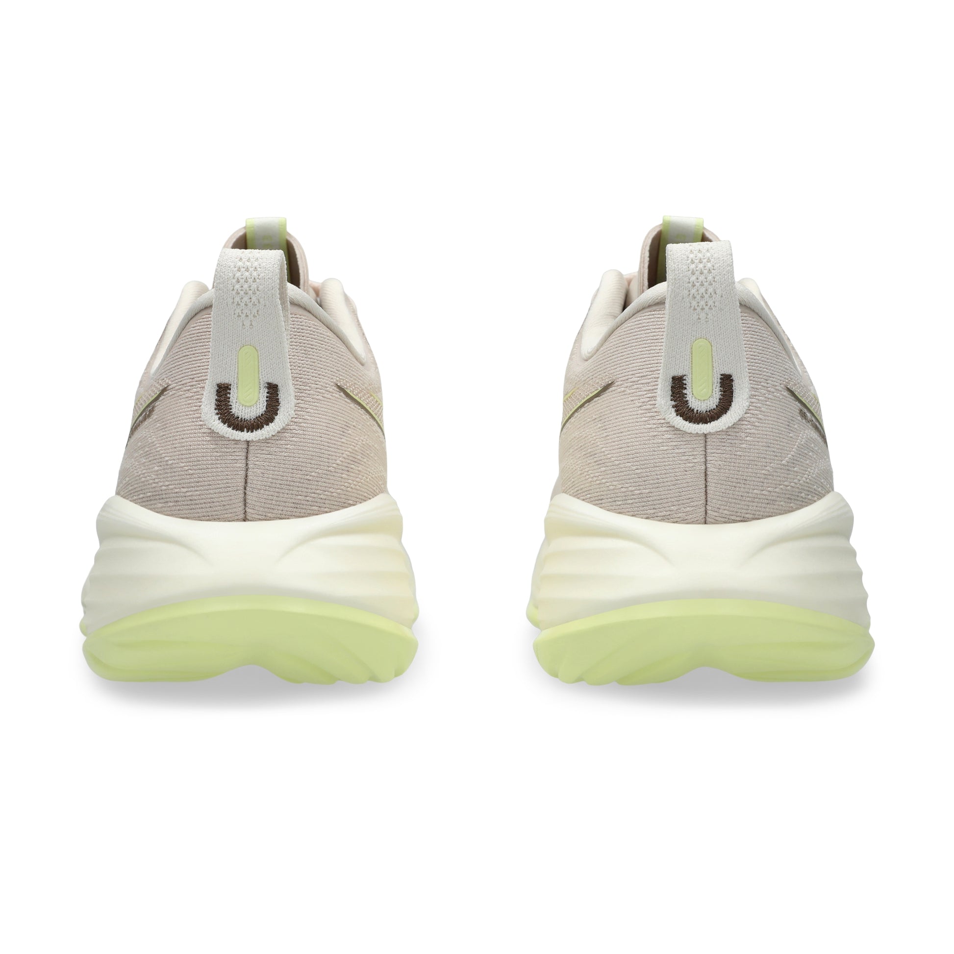 Pair of beige running shoe with green sole on a white background