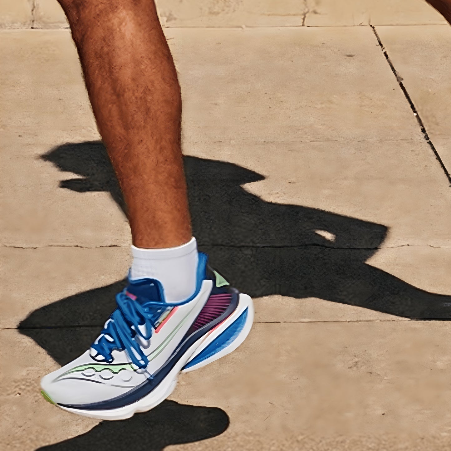 Person wearing colorful Saucony running shoes on a sidewalk