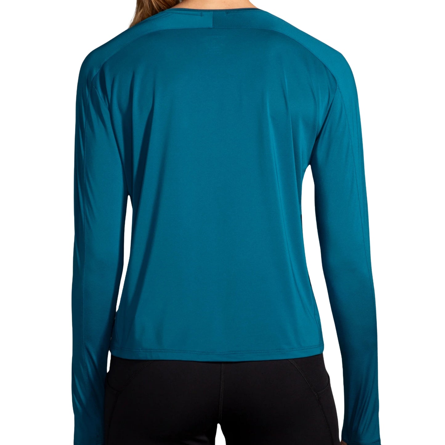 Woman wearing a blue Brooks shirt on a white background