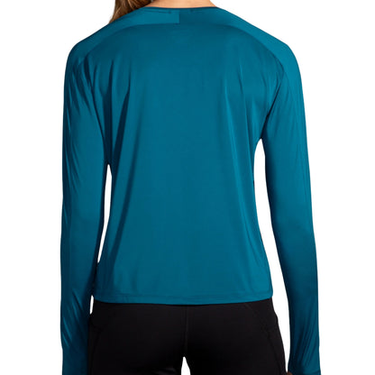 Woman wearing a blue Brooks shirt on a white background
