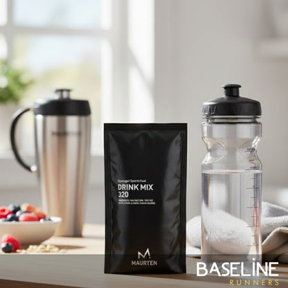 Maurten drink mix packet and clear water bottle on a table with a blurred background