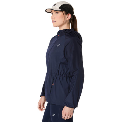 Woman wearing a navy blue jacket with a brand logo on a white background
