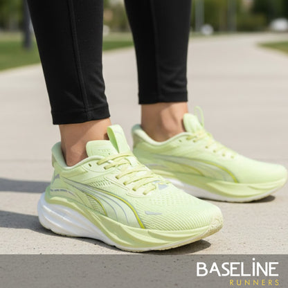Light green Puma running shoes worn by a person on a road with 'Baseline Runners' branding.