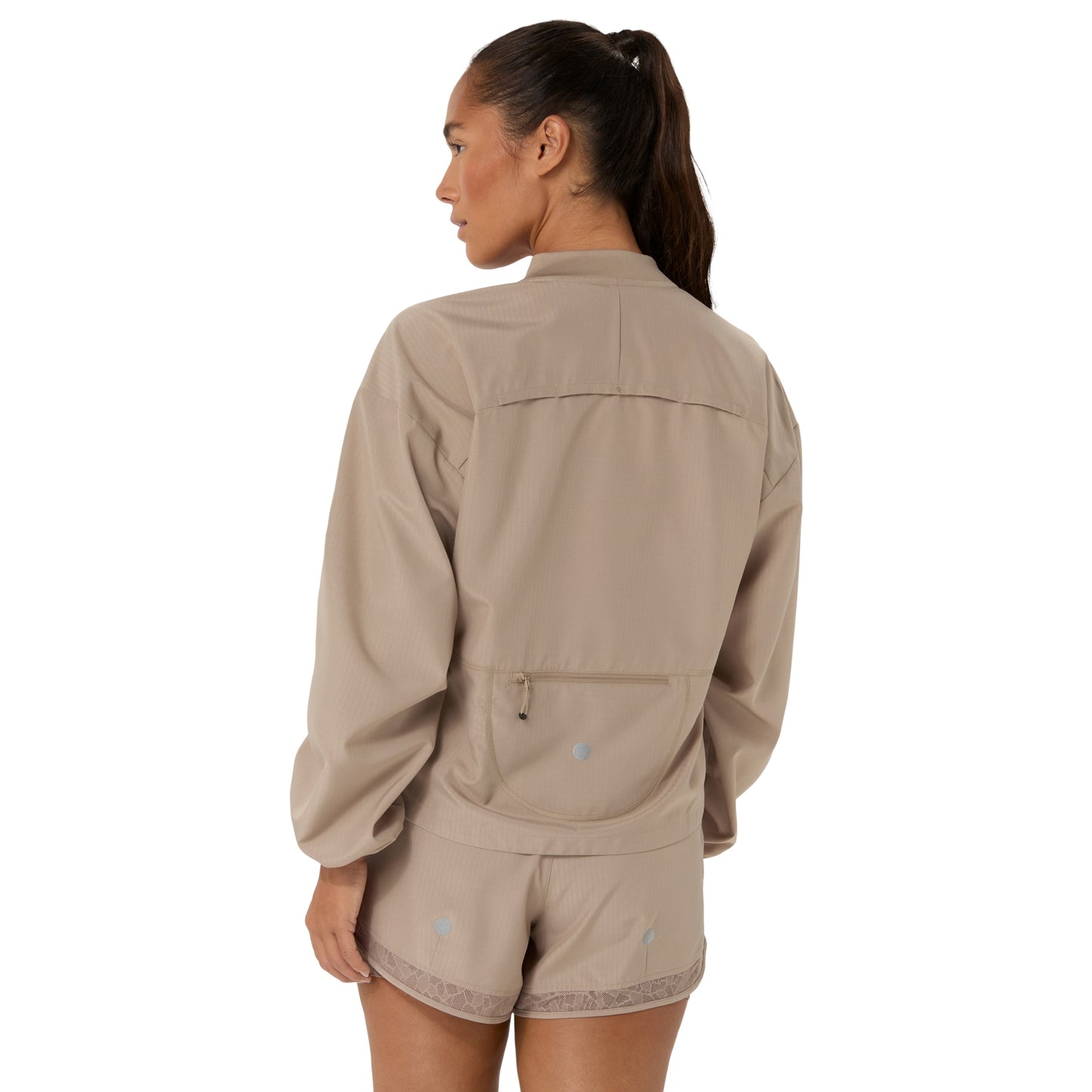 A woman shown from the back wearing a light beige matching jacket and shorts set against a plain white background.
