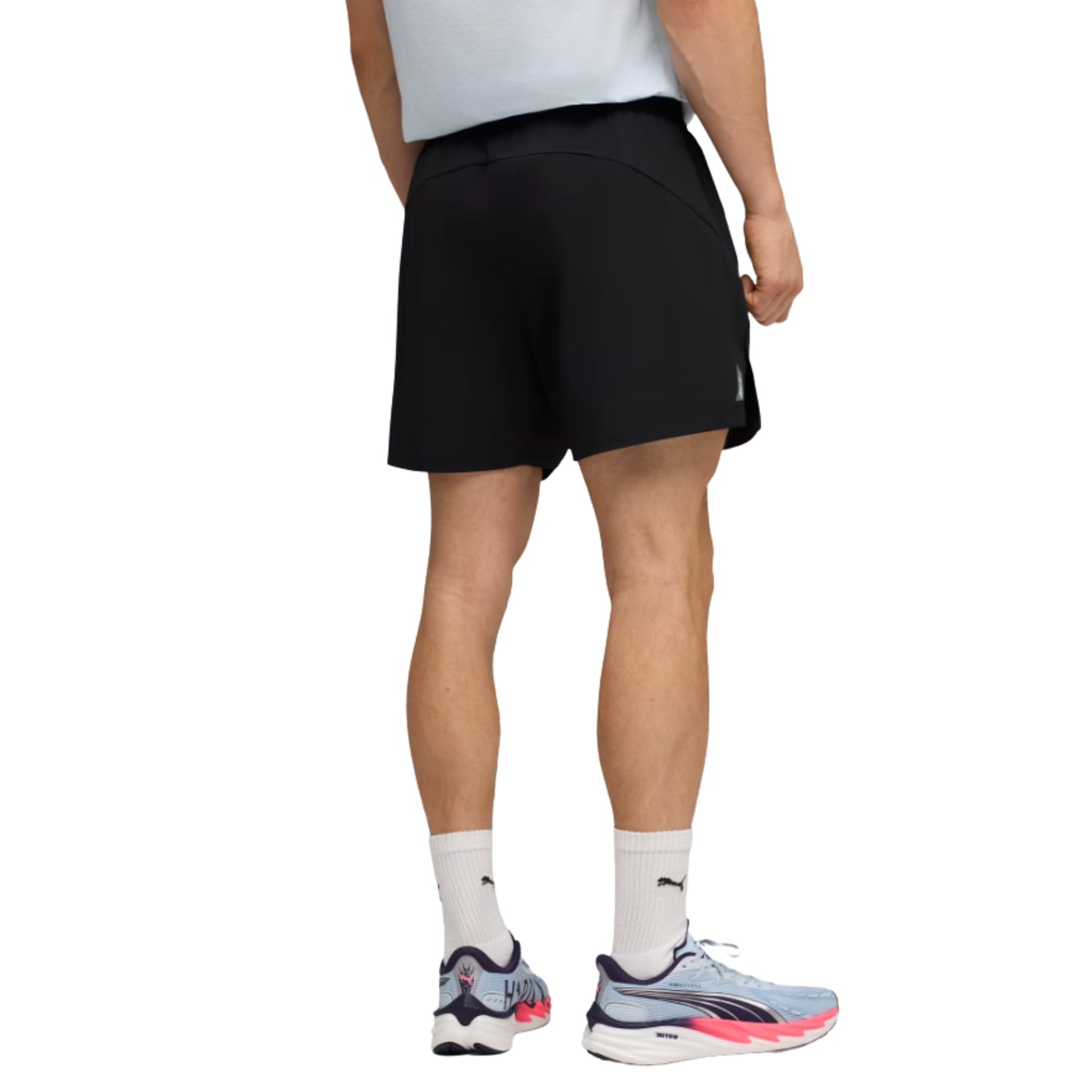 Person wearing black Puma shorts and Puma shoes on a white background