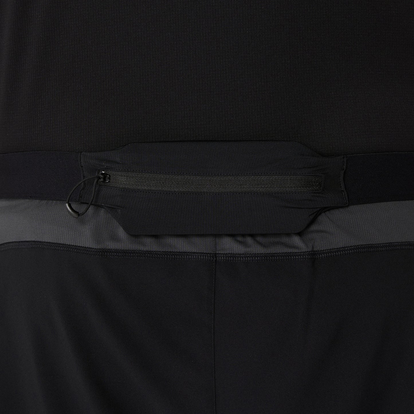 Close-up of a black and gray shorts with a zipper detail on a dark background