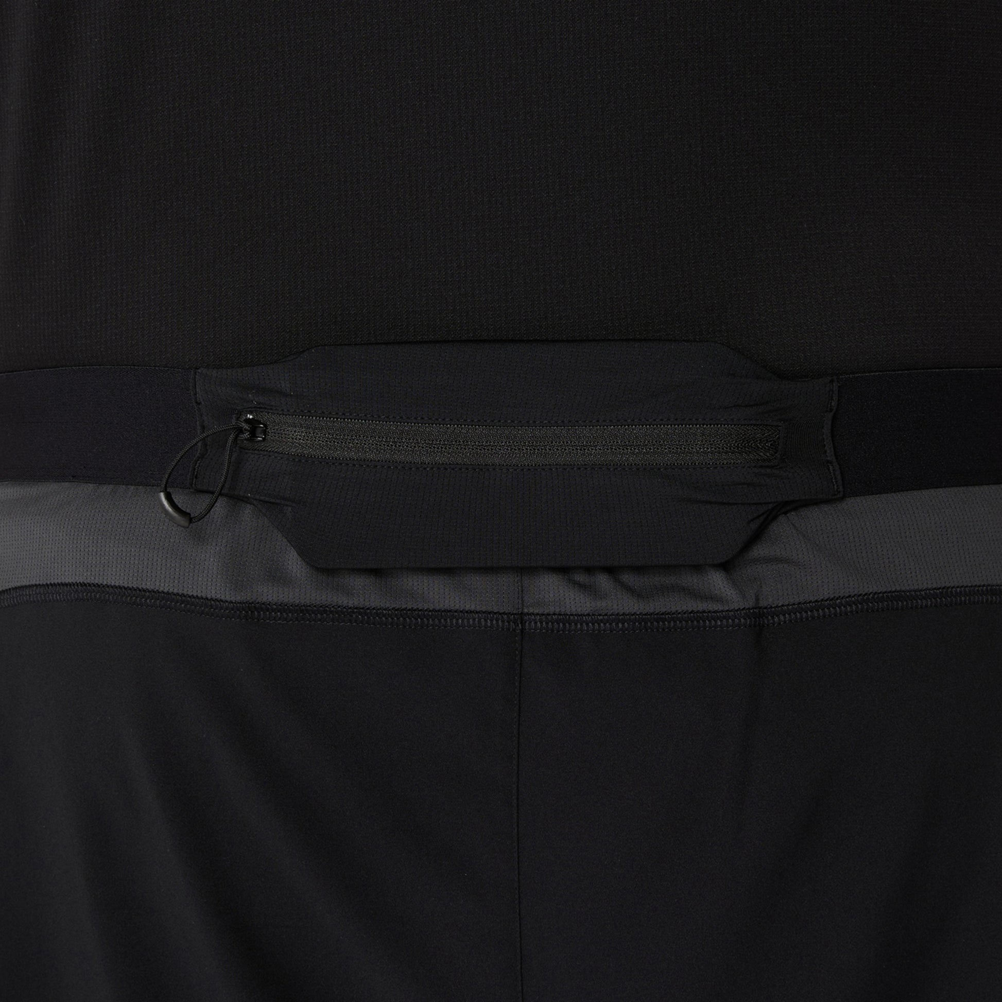 Close-up of a black and gray shorts with a zipper detail on a dark background