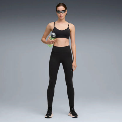 Woman wearing a black Puma tight on a grey background