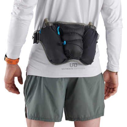 Person wearing a black waist bag with Ultimate Direction logo on a white background