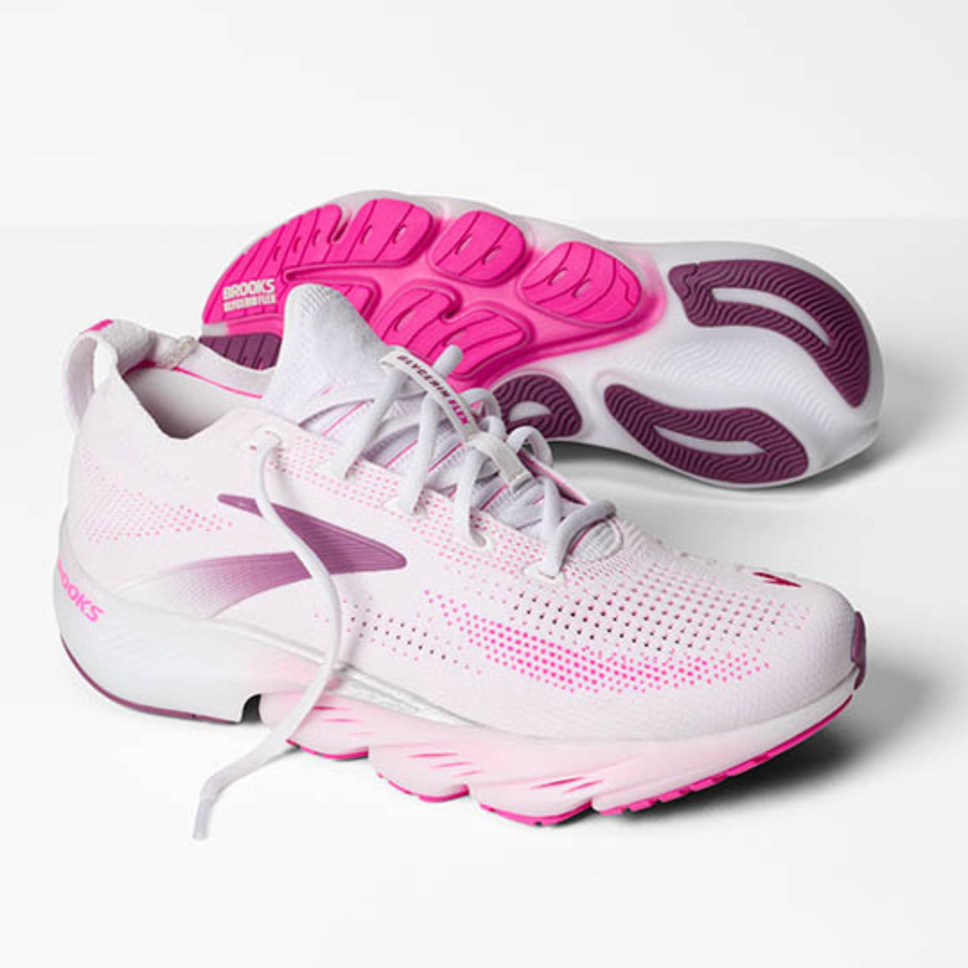 White and pink Brooks running shoes with visible brand logo on a light gray background