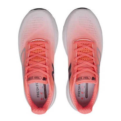Pair of coral New Balance running shoes with white soles on a white background