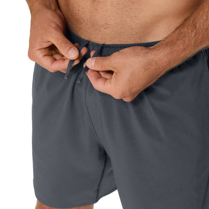 Person adjusting the drawstring of gray shorts on a white background